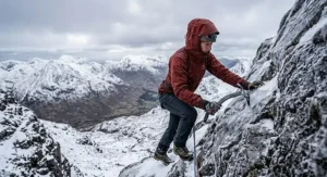 A climber wearing a durable hardshell jacket suitable for harsh UK winter climbing conditions.