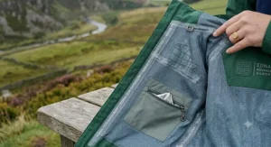 A hiker wearing a lightweight ladies hiking jacket on a rainy coastal path.