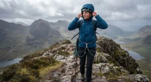 A climber wearing the best softshell jacket with an adjustable helmet-compatible hood on a windy UK peak.