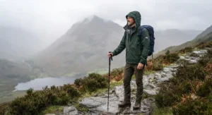 A hiker wearing a durable 3-in-1 jacket on a misty trail in the Lake District.