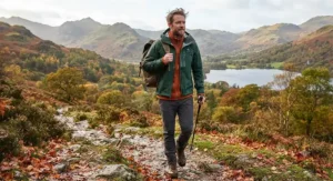A man wearing a mens hardshell jacket as an outer layer over a fleece in autumn