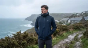 A man fully zipped up in a waterproof mens packable rain jacket, ready for unpredictable British weather.
