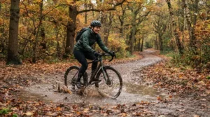 Cyclist riding through autumn puddles wearing durable cycling waterproof trousers.